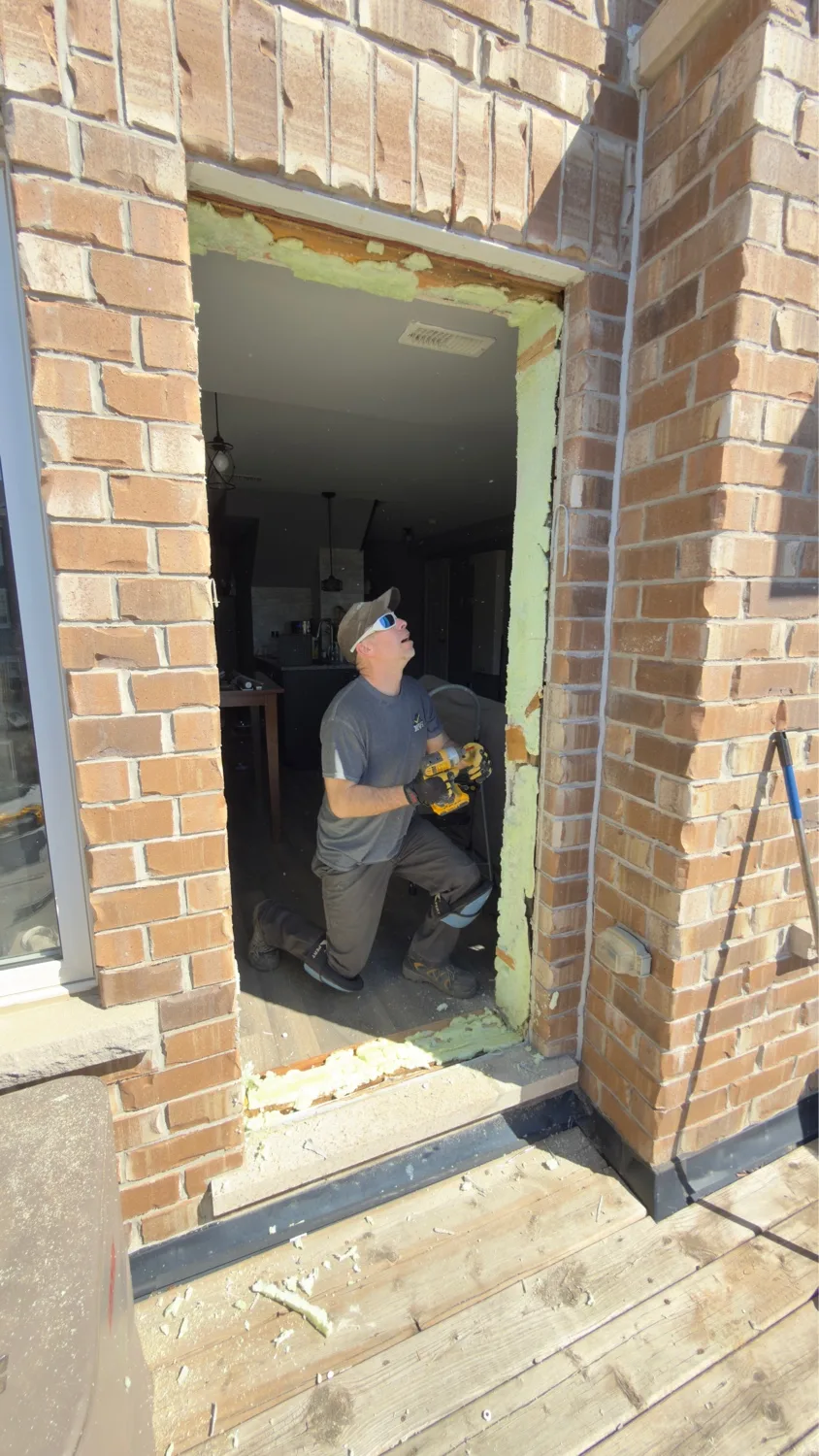 D&D Exterior Finishing installer prepping rough door opening from inside — Kitchener-Waterloo