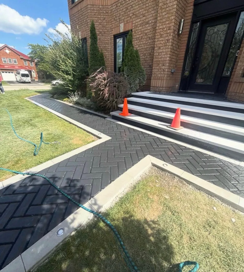 Herringbone interlock walkway with concrete steps and landscaping at front entrance — D&D Exterior Finishing