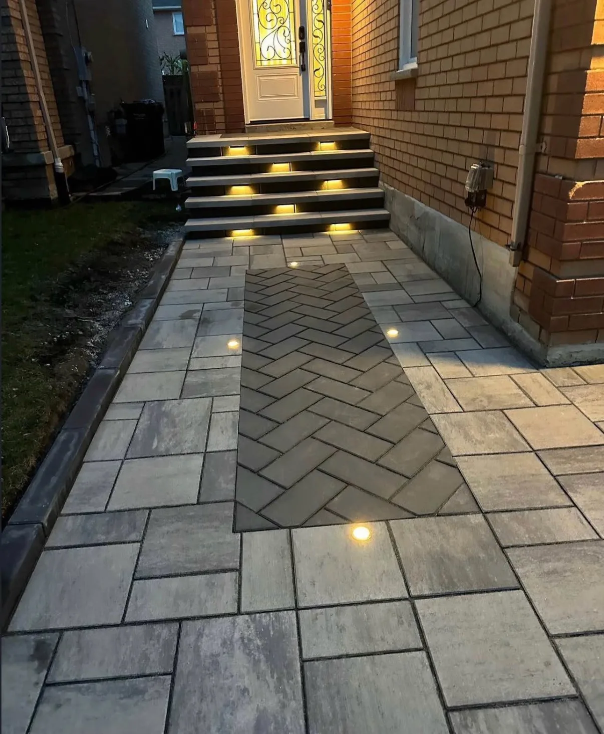 Interlock herringbone walkway with uplighting and stone-capped steps β D&D Exterior Finishing Kitchener-Waterloo